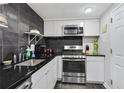 Modern kitchen featuring stainless steel appliances, dark countertops, and black backsplash at 1501 Clairmont Rd # 1522, Decatur, GA 30033