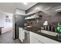 View of the modern kitchen featuring black countertops and backsplash with stainless steel appliances at 1501 Clairmont Rd # 1522, Decatur, GA 30033