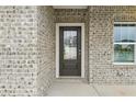 A welcoming front entrance featuring a black front door, brick facade, and a charming window at 6905 Winchester Pl, Fairburn, GA 30213