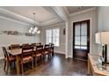 Dining area with seating for eight, hardwood flooring, and a stylish pendant light fixture at 919 Olmsted Ln, Johns Creek, GA 30097