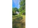 Charming home featuring a spacious front yard and a welcoming entrance, nestled among mature trees at 144 Wiley Dr, Douglasville, GA 30134