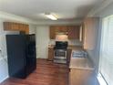 Kitchen with stainless steel appliances, wood cabinets, and laminate flooring at 5340 Forest Pl, Stone Mountain, GA 30088