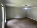Spacious living room featuring neutral paint, carpet flooring and a ceiling fan with light at 5340 Forest Pl, Stone Mountain, GA 30088