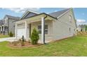 Single Gathering home featuring light brick, white trim, covered porch, and a well manicured lawn at 6908 Winchester Pl, Fairburn, GA 30213