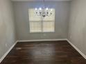 Dining room with hardwood floors, a classic chandelier, and a large window at 1247 To Lani Farm Rd, Stone Mountain, GA 30083