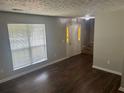 Cozy living room with hardwood floors, staircase, and a bright window for natural light at 1247 To Lani Farm Rd, Stone Mountain, GA 30083