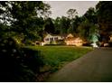 Nighttime view of the home surrounded by trees, with a driveway and subtle exterior lighting at 45 Michelle Ne Cir, Atlanta, GA 30342