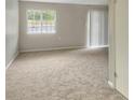 A spacious living room with neutral carpet and a large window for ample natural light at 475 Mount Vernon Ne Hwy # 129C, Atlanta, GA 30328
