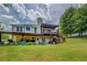 Spacious backyard features a covered patio, upper deck, mature trees, and plenty of space for recreation at 75 Puppy Chase, Social Circle, GA 30025