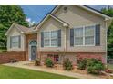 Charming home featuring blue shutters, brick accents, fresh flowers and a lovely arched front door at 75 Puppy Chase, Social Circle, GA 30025