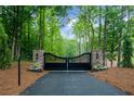 Elegant black driveway gate with brick pillars, enhancing privacy and adding curb appeal to the property at 1084 Wrights Mill Rd, Canton, GA 30115