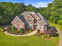 Beautiful brick home featuring manicured landscaping and a circular driveway at 5360 Franklin Goldmine Rd, Cumming, GA 30028
