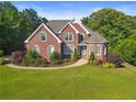 Charming brick home with a well-manicured lawn and beautiful landscaping at 5360 Franklin Goldmine Rd, Cumming, GA 30028