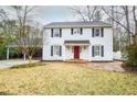 Attractive two-story white home with a red front door and a covered parking area at 970 Winding Creek Trl, Sandy Springs, GA 30328