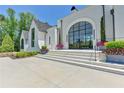 The grand entrance features a large arched window door, with stone steps and manicured landscaping at 2305 Braselton Hwy, Buford, GA 30519