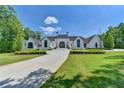 Stunning white brick home boasts a symmetrical design, manicured landscaping and circular driveway at 2305 Braselton Hwy, Buford, GA 30519