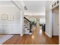 Inviting foyer with hardwood floors, staircase with iron spindles, and elegant wainscoting at 3310 Chartwell Blvd, Suwanee, GA 30024