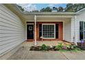 Inviting covered front porch with brick accents and charming garden area at 425 Charlyne Way, Dacula, GA 30019