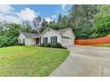 Charming single-story home with a well-maintained lawn, driveway and mature trees at 425 Charlyne Way, Dacula, GA 30019