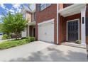 Exterior shot of a brick townhome with a one-car garage and sidewalk at 5686 Lawley Dr, Alpharetta, GA 30022