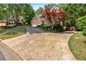 Long driveway leading up to a classic brick home with mature landscaping and a two-car garage at 6034 Addington Nw Dr, Acworth, GA 30101