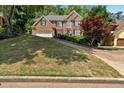 Classic brick home featuring manicured landscaping and mature trees, offering great curb appeal at 6034 Addington Nw Dr, Acworth, GA 30101
