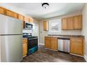 Functional kitchen with stainless steel appliances, wood cabinets, and laminate floors at 2497 Lakewood Sw Ave, Atlanta, GA 30315