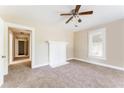 Inviting living room featuring a white fireplace, ceiling fan, and neutral carpet at 2497 Lakewood Sw Ave, Atlanta, GA 30315