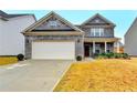 Attractive two-story home with a gray brick exterior, attached garage, and well-maintained front yard at 5452 Fountainhead Ln, Auburn, GA 30011