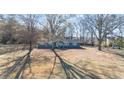 Inviting single-story home featuring mature trees and a sprawling front lawn at 9588 Poston Rd, Jonesboro, GA 30238