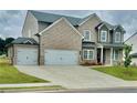 Elegant exterior view of a two-story home showcasing a spacious driveway and three-car garage at 98 Longhorn Way, Auburn, GA 30011