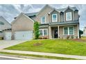 Attractive two-story home with well-maintained lawn, three-car garage, and brick and siding accents at 98 Longhorn Way, Auburn, GA 30011