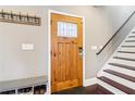 Warm entryway with a wooden door, coat rack, storage bench, and staircase at 1977 Nash Se Ave, Atlanta, GA 30316