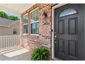 Welcoming covered brick porch featuring a black front door and decorative fern at 3845 New Salem Ct, Cumming, GA 30040