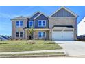 Inviting two-story home featuring a manicured lawn, attached two-car garage, and charming architectural details at 58 Longhorn Way, Auburn, GA 30011
