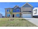 Charming two-story home with a well-kept lawn, a two-car garage and a lovely tree in the yard at 58 Longhorn Way, Auburn, GA 30011