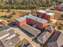 Expansive aerial view showcasing red brick multi-unit building with parking nestled among lush greenery and nearby homes at 4143 N Swann St, Covington, GA 30014
