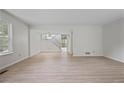 Bright living room with large window, light wood-look flooring and access to staircase at 2117 Bucktrout Pl, Dunwoody, GA 30338