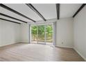 Living room featuring wood floors, beamed ceilings, and a sliding door to the outdoor patio at 2117 Bucktrout Pl, Dunwoody, GA 30338