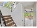 Staircase with a black handrail, carpeted stairs, and a view of the outdoor patio at 2117 Bucktrout Pl, Dunwoody, GA 30338