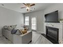 Cozy living room featuring a fireplace, ceiling fan, and a neutral color palette at 3194 Mill Springs Cir, Buford, GA 30519