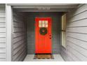 Inviting front entrance featuring a vibrant red door, wreath, and a 'Home Sweet Home' doormat at 1280 Gin House Ln, Lawrenceville, GA 30045