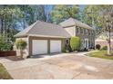 Exterior view of a two-story home, with a large driveway and well manicured shrubbery at 1627 Isham Dr, Lawrenceville, GA 30046