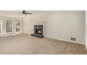 Spacious living room featuring a cozy fireplace, ceiling fan, and natural light at 1627 Isham Dr, Lawrenceville, GA 30046