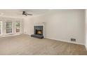 Bright living room with a cozy fireplace and access to the outdoors through French doors at 1627 Isham Dr, Lawrenceville, GA 30046