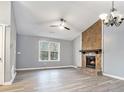 Spacious living room with a vaulted ceiling, stone fireplace, and large window offering natural light at 3918 S Creek Ct, Stone Mountain, GA 30083
