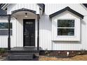 Front door with black trim and accent window, complimented by landscaping and fresh mulch at 65 Sage St, Temple, GA 30179
