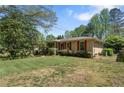 Traditional home with a lush green lawn and mature trees at 2062 Cezar Nw Dr, Kennesaw, GA 30152