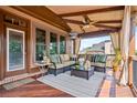 Relaxing covered porch with comfortable seating, ceiling fan, and view of the backyard at 2400 Gants Hill Pl, Cumming, GA 30041