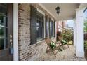 Inviting front porch with brick accents, stylish seating, and a charming outdoor lighting fixture at 4884 Kentwood Dr, Marietta, GA 30068
